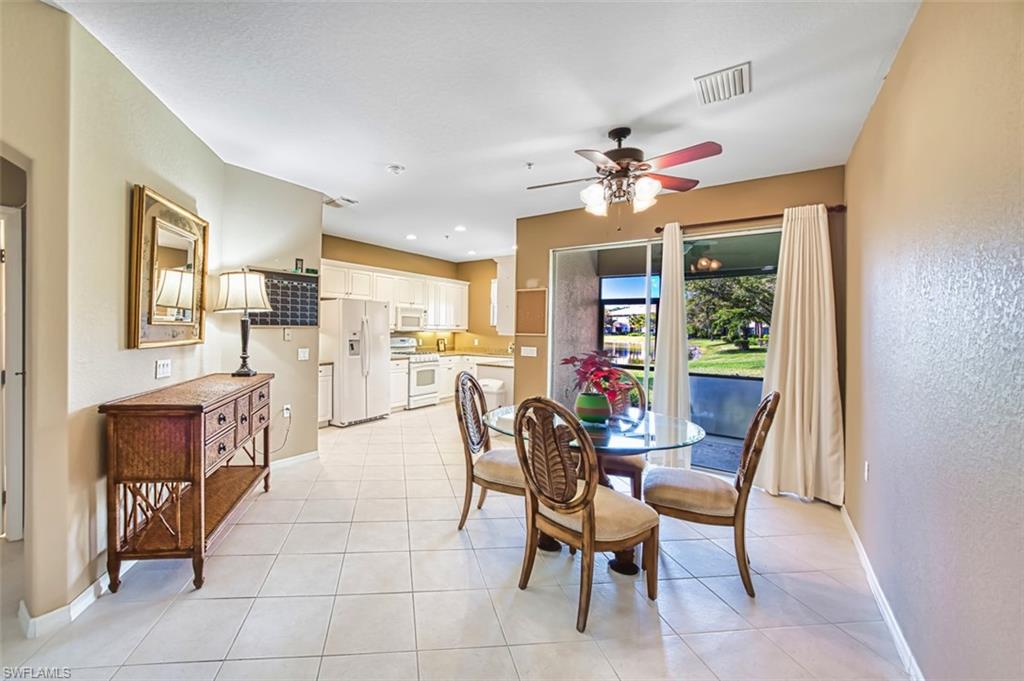Dining space with light tile patterned flooring, ceiling fan, a textured wall, and recessed lighting