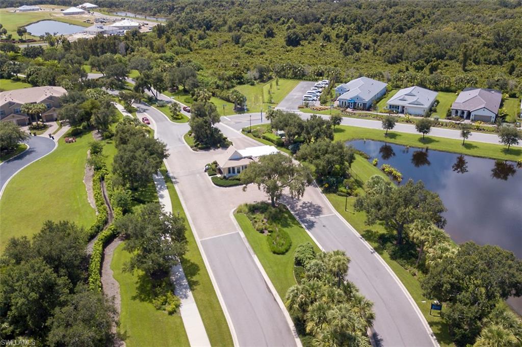 Aerial perspective of suburban area featuring a large body of water and a heavily wooded area