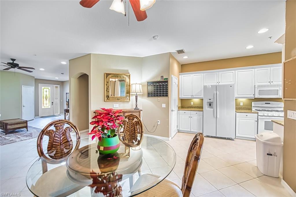 Dining space with a ceiling fan, recessed lighting, arched walkways, and light tile patterned floors