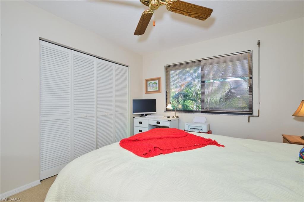 Bedroom featuring ceiling fan, a closet, and light colored carpet
