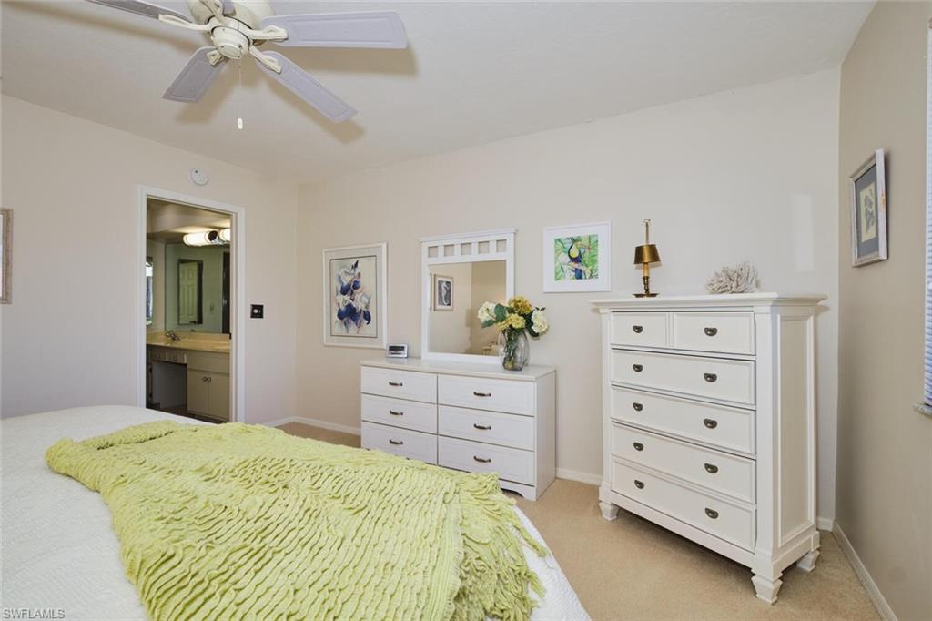 Bedroom featuring ensuite bathroom, light colored carpet, and ceiling fan