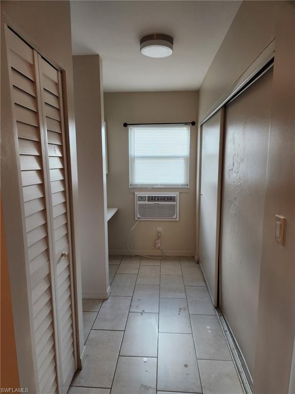 Corridor with a wall mounted AC and light tile patterned floors