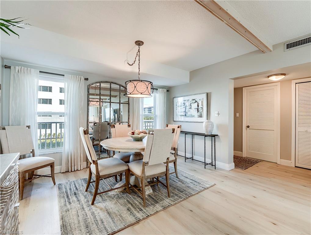 Dining room with light wood-style flooring and beam ceiling