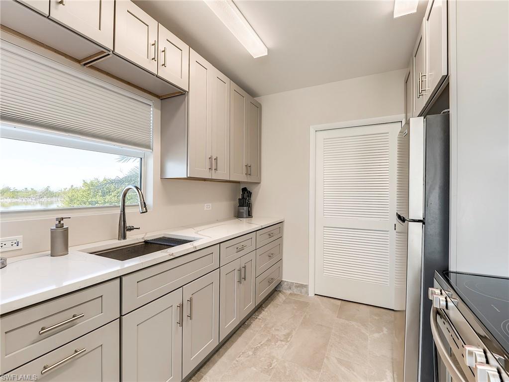 New Community Kitchen featuring gray cabinets, stainless steel appliances, and light stone countertops