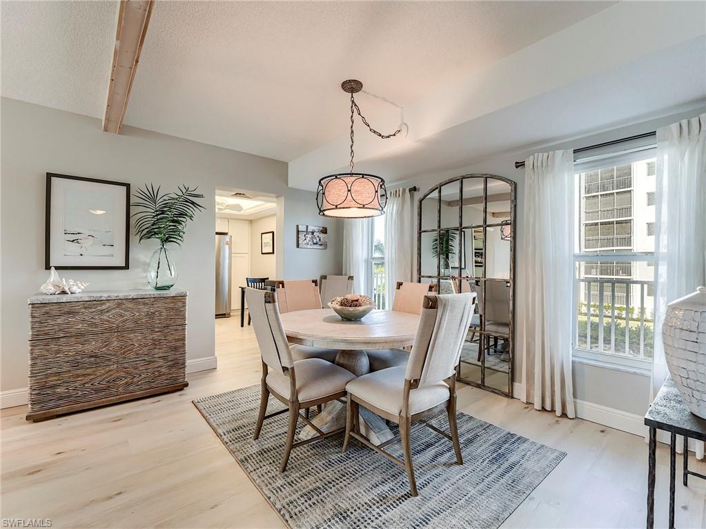 Dining area featuring light wood finished floors and beam ceiling