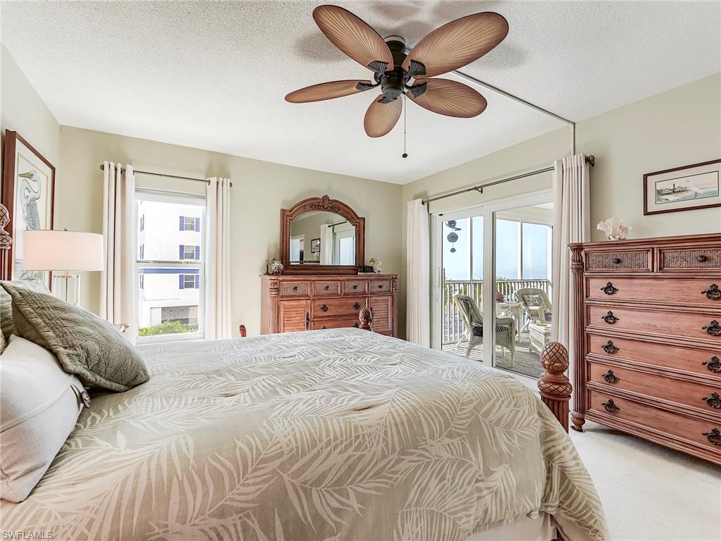 Carpeted bedroom featuring access to exterior, a textured ceiling, and ceiling fan