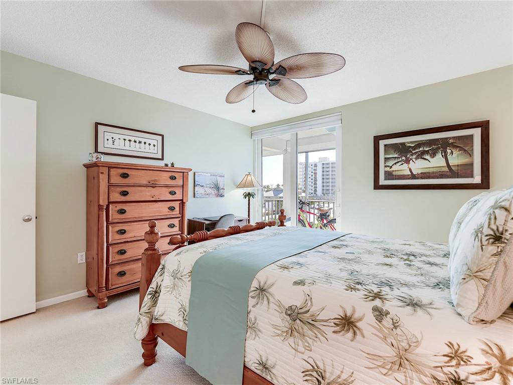 Bedroom with access to outside, carpet floors, a ceiling fan, and a textured ceiling