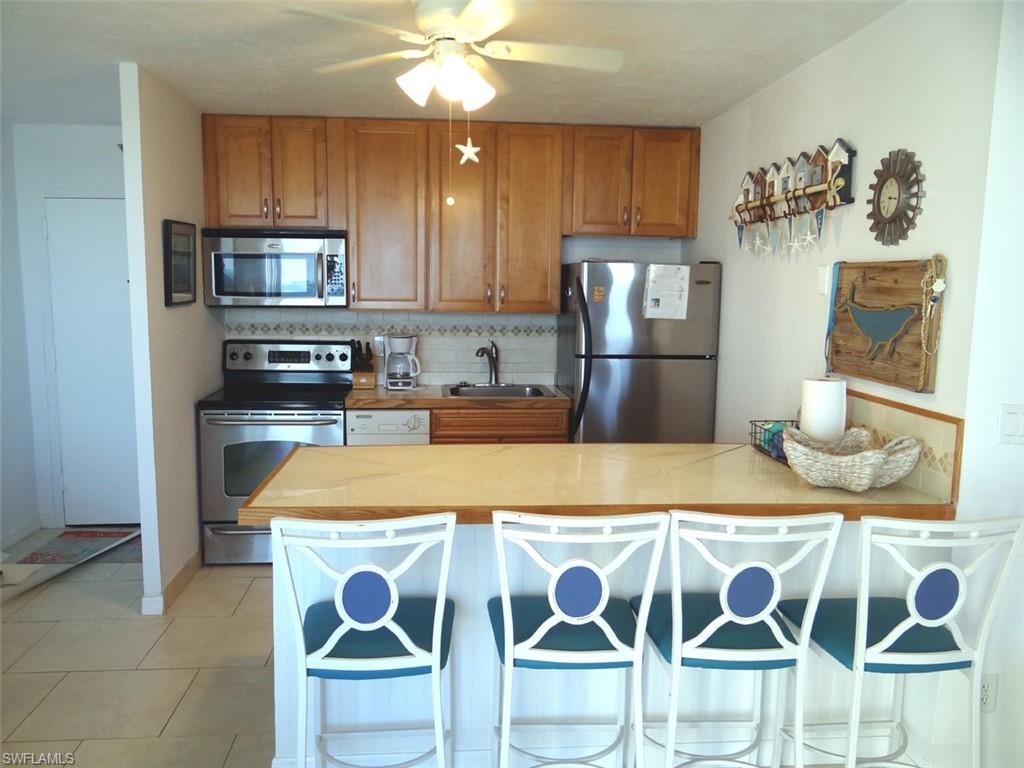 Kitchen with appliances with breakfast bar area