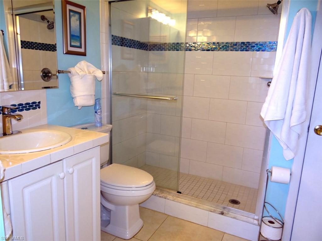 Full bath with vanity, a stall shower, and light tile patterned floors