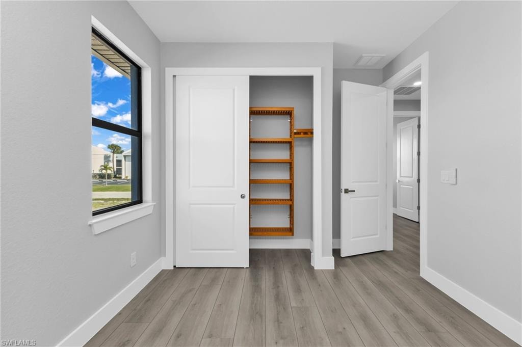 Unfurnished bedroom featuring light wood-style flooring and a closet