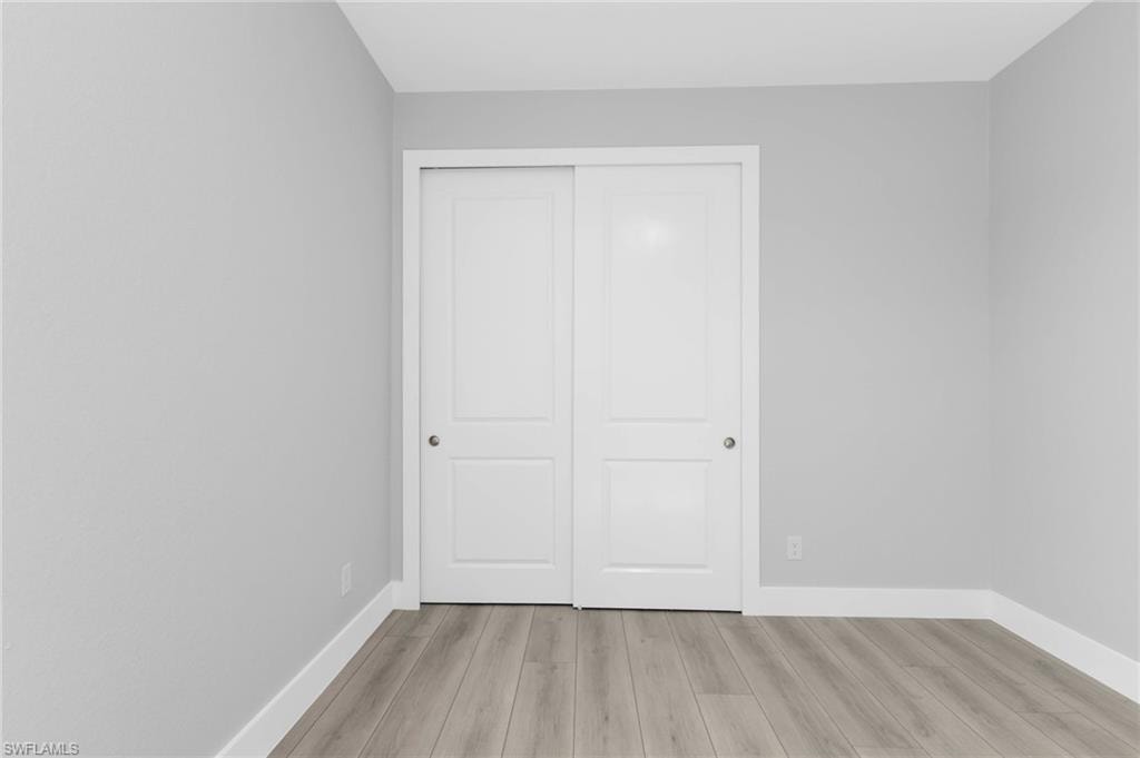 Unfurnished bedroom featuring light wood finished floors and a closet