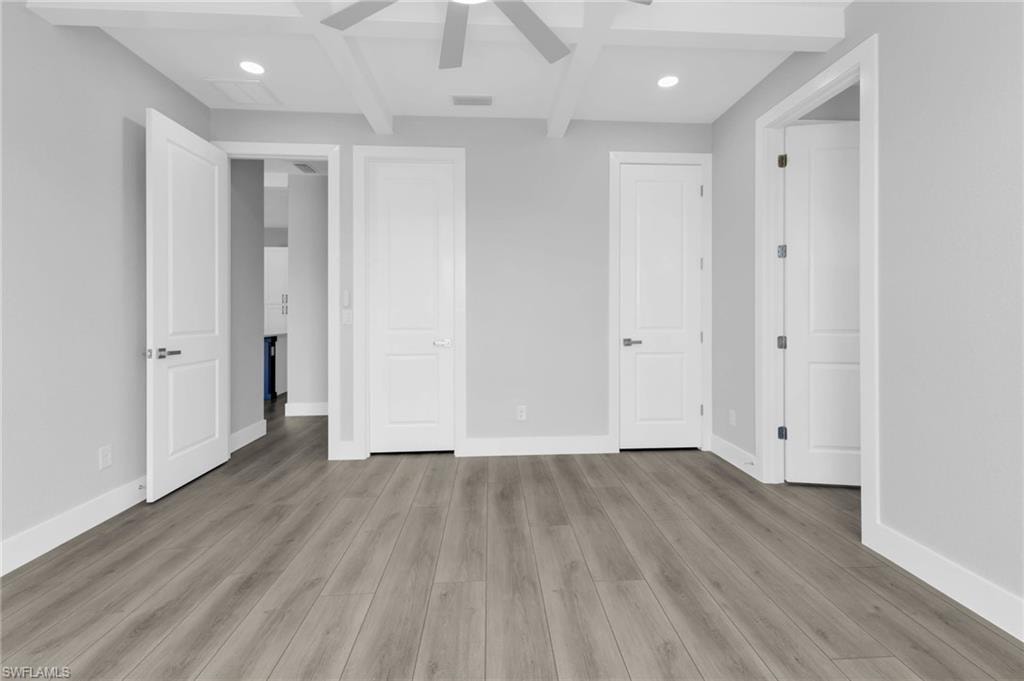 Unfurnished bedroom featuring beam ceiling, light wood-style flooring, recessed lighting, coffered ceiling, and a ceiling fan