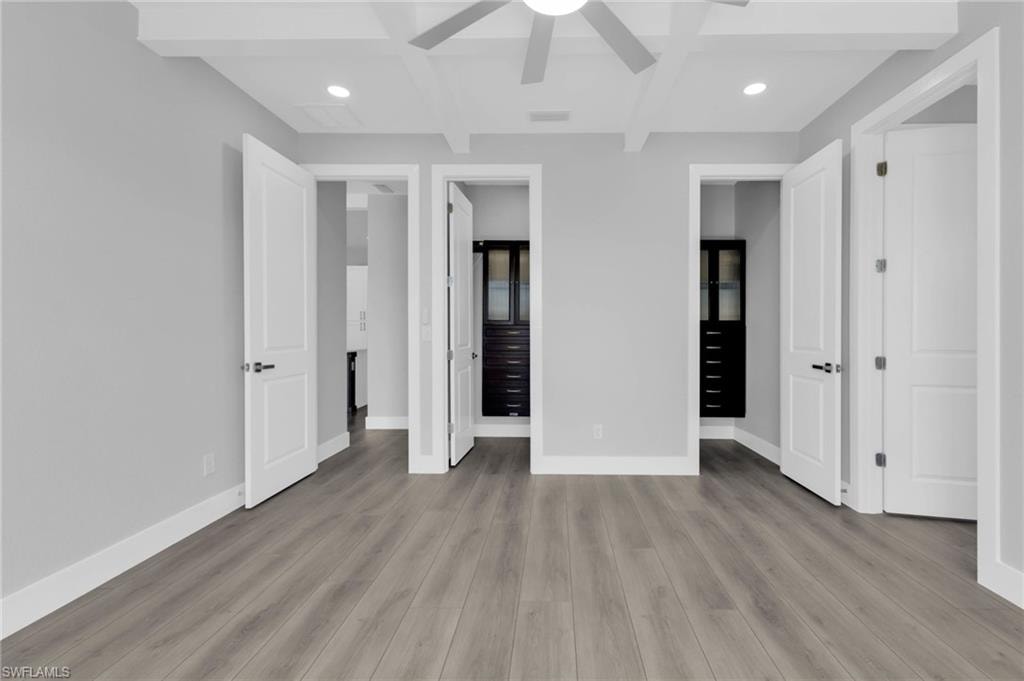 Unfurnished bedroom with beamed ceiling, coffered ceiling, recessed lighting, light wood-type flooring, and ceiling fan