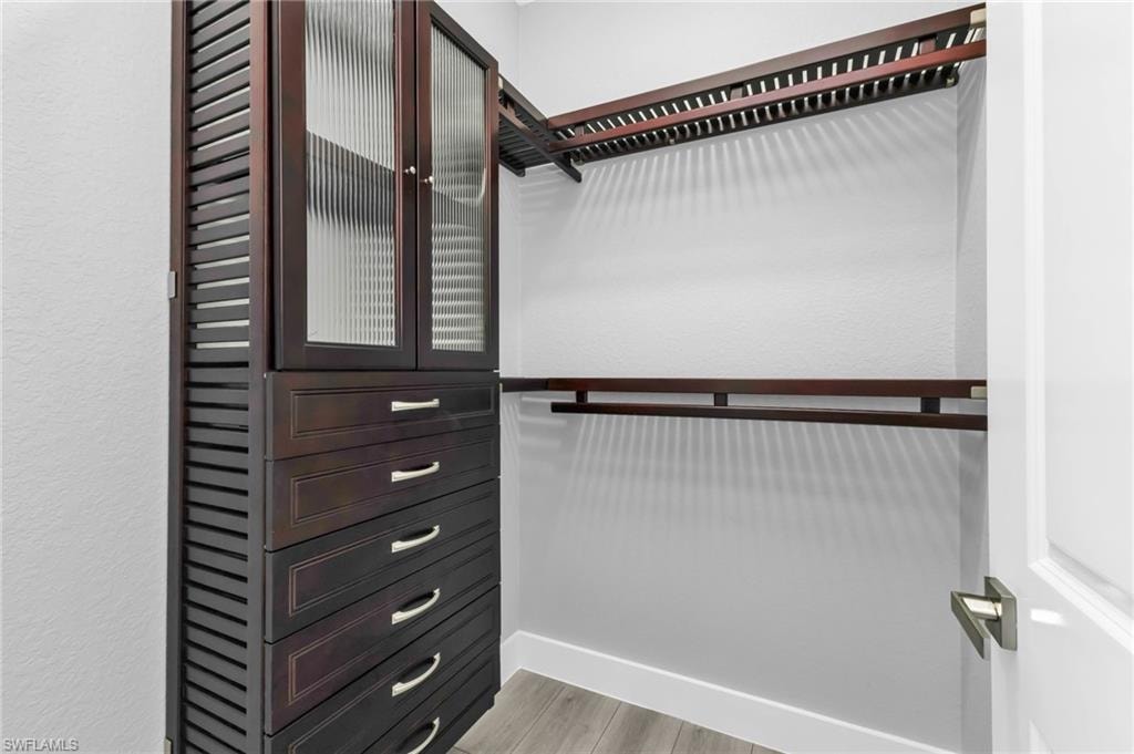 Walk in closet with light wood finished floors