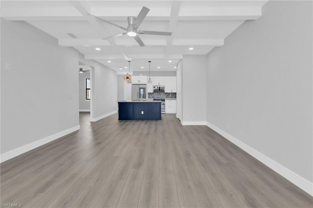 Unfurnished living room with coffered ceiling, beamed ceiling, recessed lighting, a ceiling fan, and dark wood-style floors
