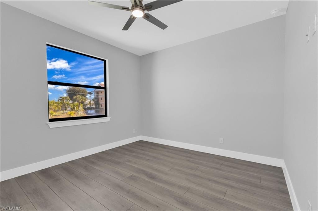 Unfurnished room featuring wood finished floors and ceiling fan