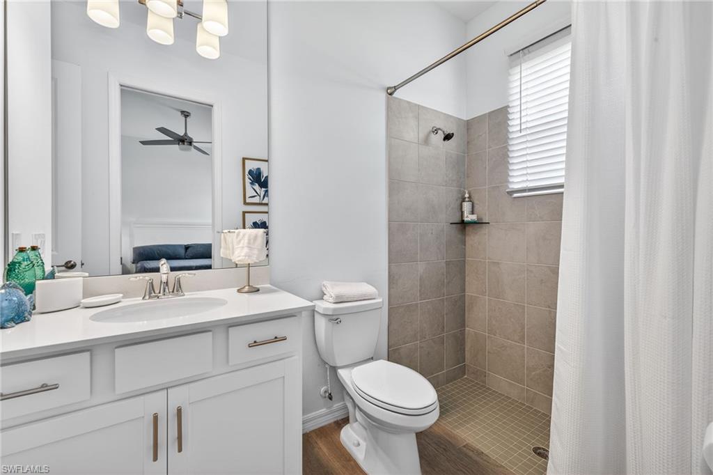Ensuite bathroom with a stall shower, vanity, and a ceiling fan