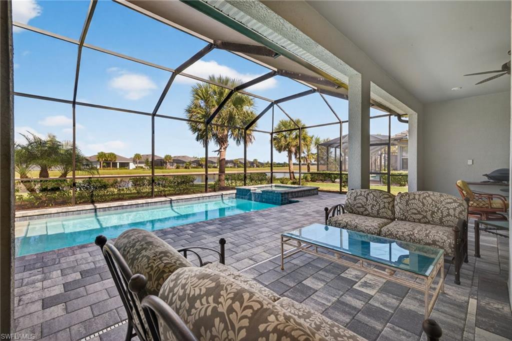View of swimming pool featuring a sunroom, a patio area, an outdoor living space, glass enclosure, and a residential view