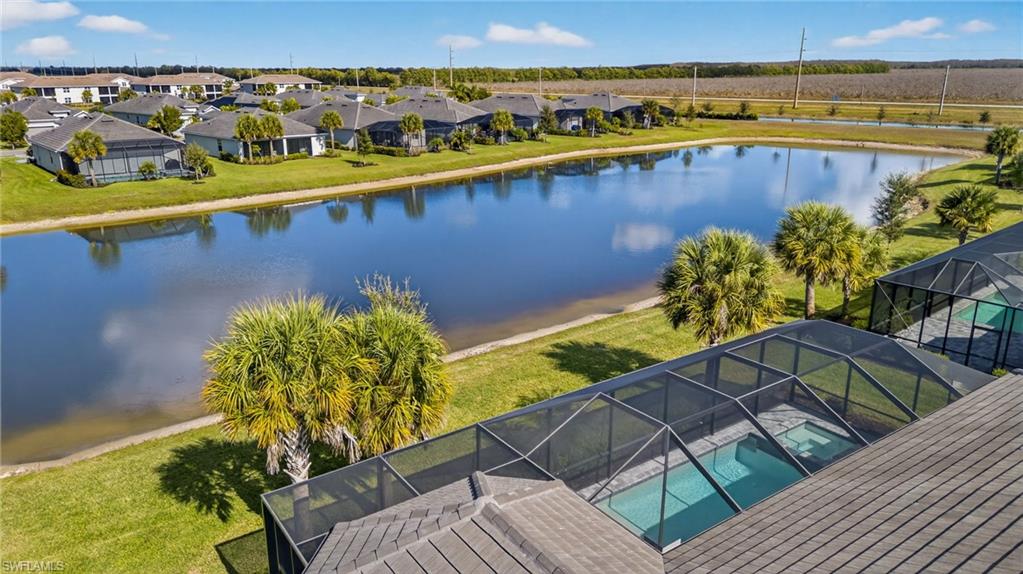 Aerial view of residential area with a nearby body of water and a pool area