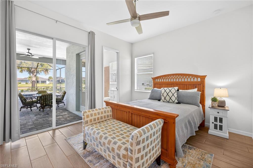 Bedroom featuring wood finish floors, access to exterior, multiple windows, and a ceiling fan