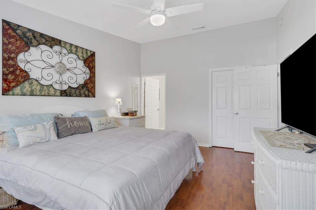 PrimaryBedroom1 featuring dark wood-style flooring, a ceiling fan, and a shelved, walk-in closet