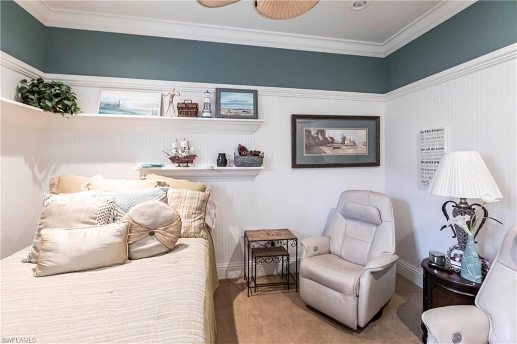 Bedroom featuring crown molding, carpet, and wainscoting