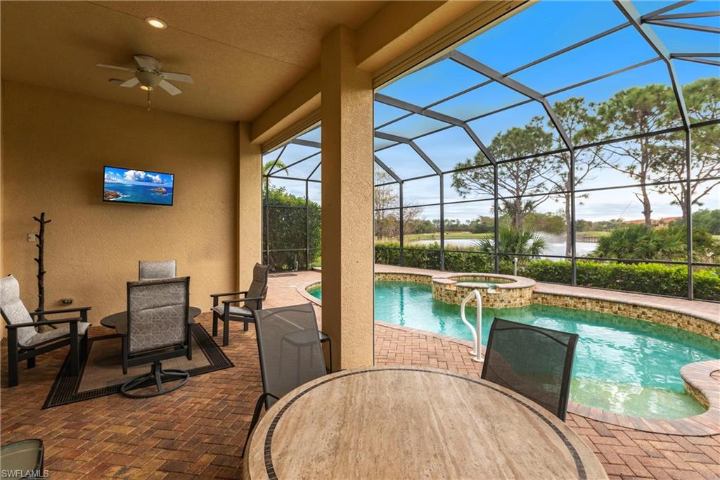 View of pool featuring a sunroom, a patio, a lanai, outdoor dining space, and a pool with connected hot tub
