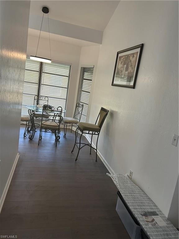 Dining area featuring dark wood-type flooring and lofted ceiling