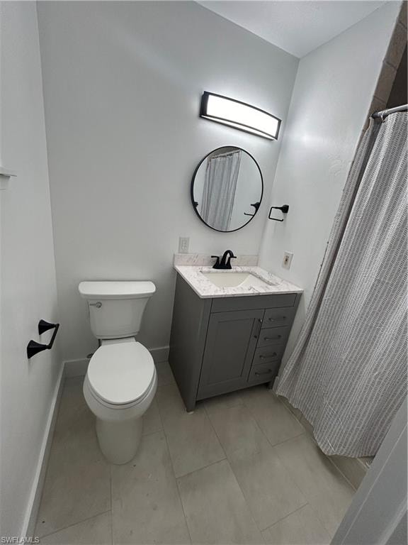 Bathroom with tile patterned flooring, vanity, toilet, and curtained shower
