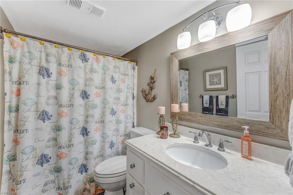 The second full bath features a shower/tub combination, modern cabinetry, a stunning mirror, and contemporary lighting, blending style and functionality.