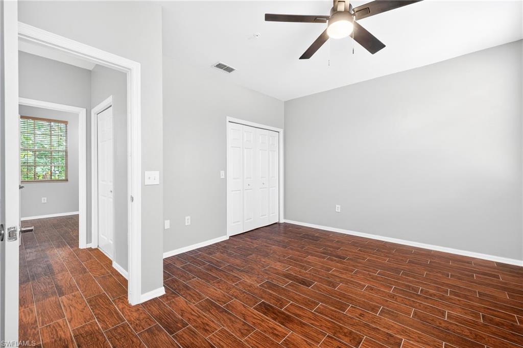 Unfurnished bedroom with a closet, wood tiled floors, and a ceiling fan