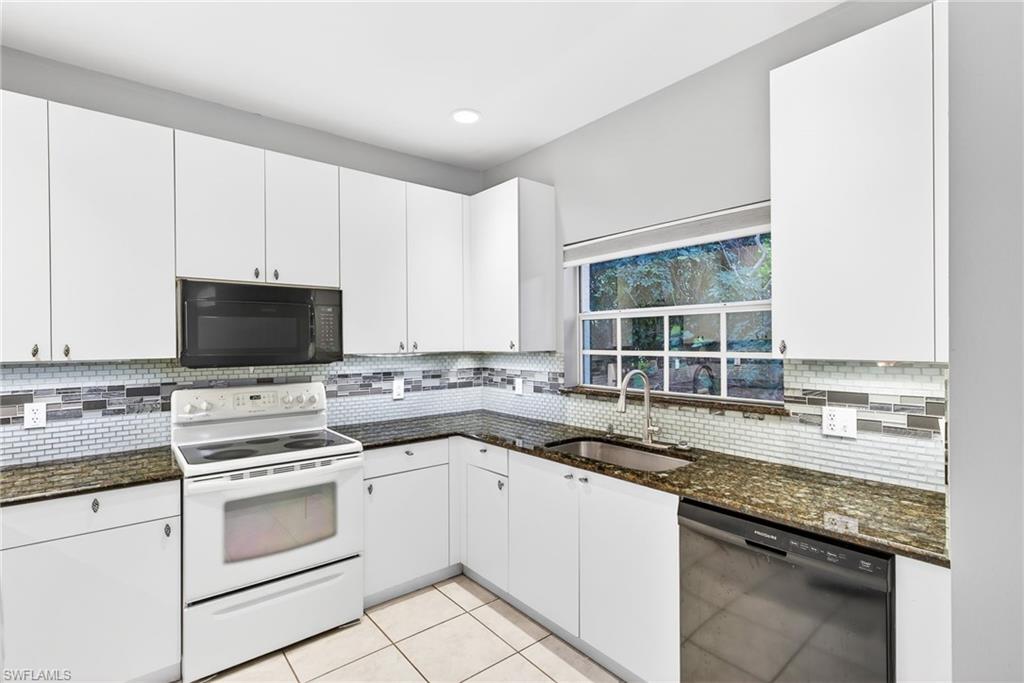 Kitchen featuring black appliances, dark stone counters, tasteful backsplash, white cabinetry, and recessed lighting
