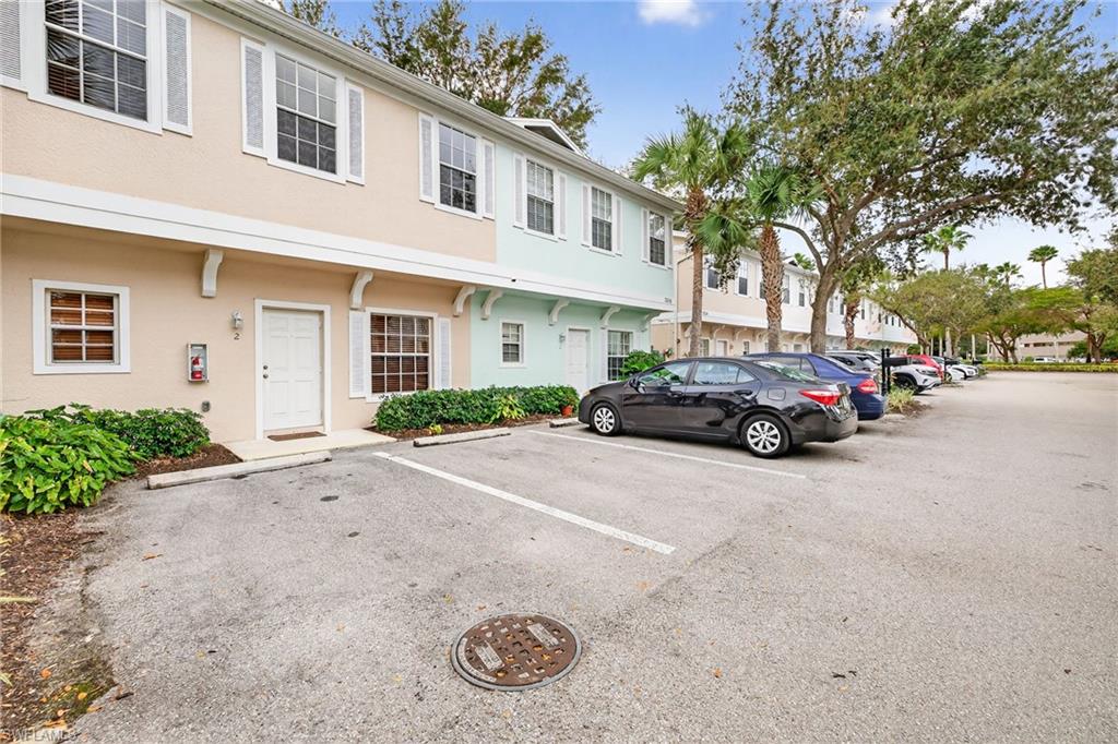 View of building exterior featuring uncovered parking and a residential view