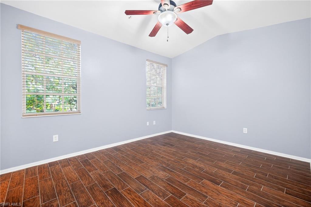 Unfurnished room featuring wood tiled floors, lofted ceiling, and ceiling fan