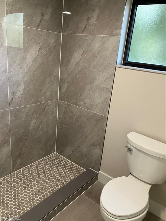 Bathroom featuring a shower stall and tile patterned flooring