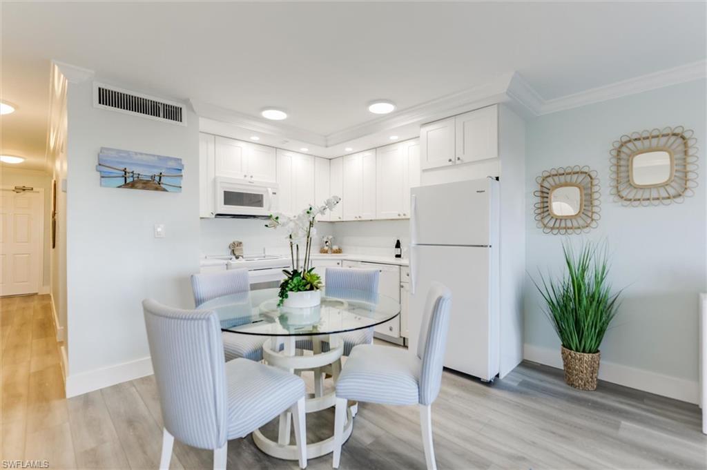 Dining room with light wood-type flooring, crown molding, and recessed lighting