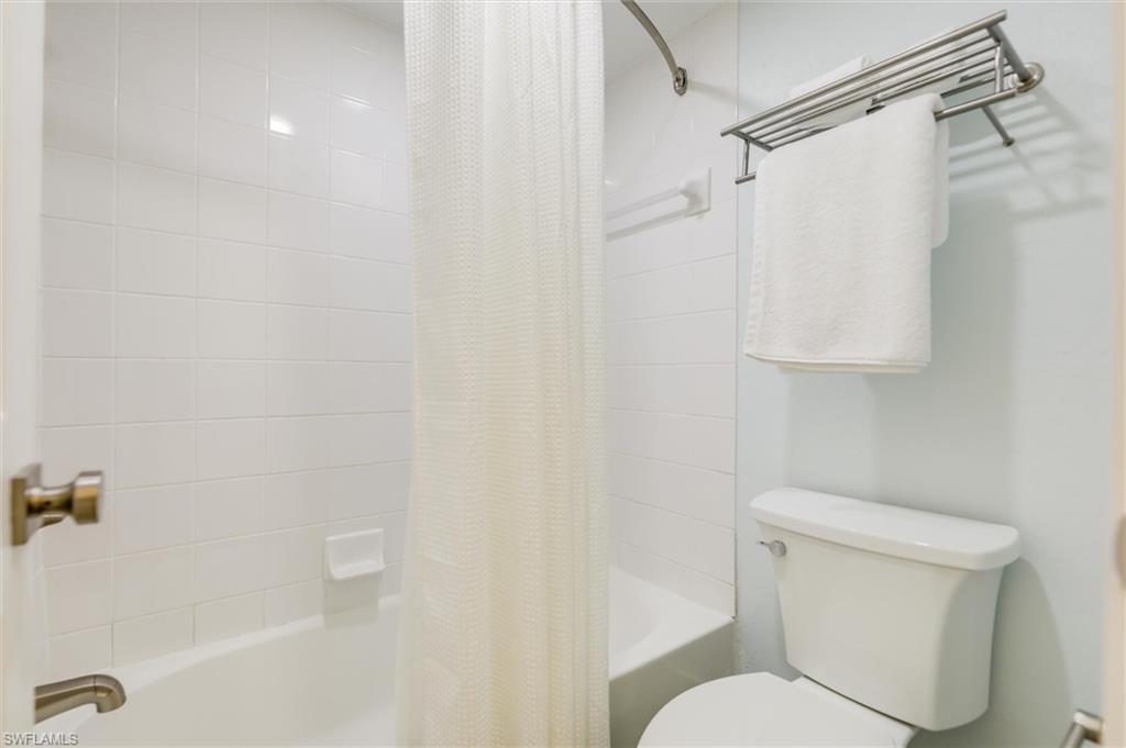 Full bathroom with shower / bath combination with curtain and toilet