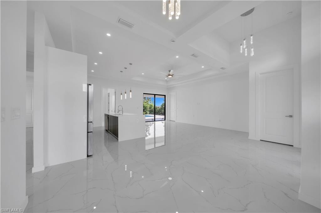 Unfurnished living room featuring recessed lighting, light marble finish floors, and a ceiling fan