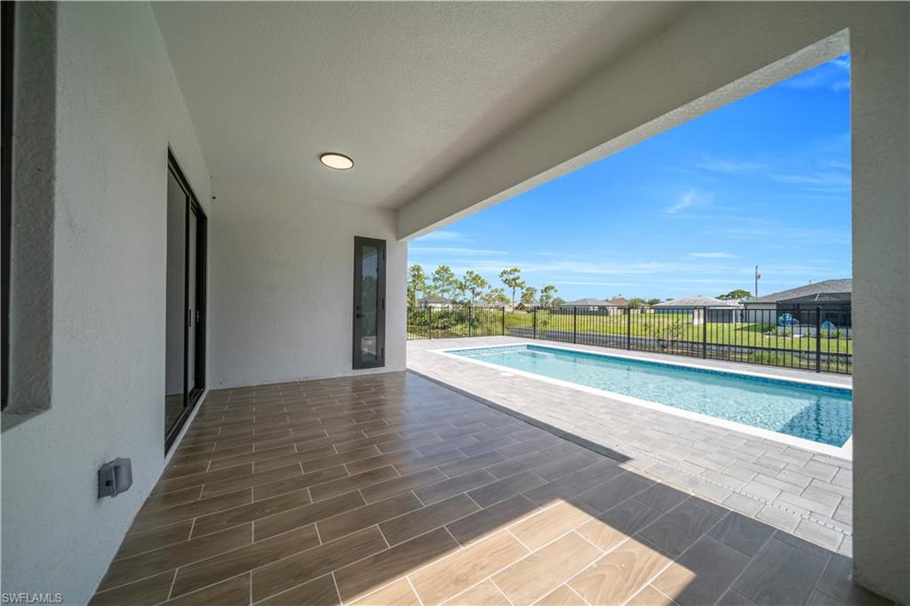 View of swimming pool featuring patio surround, a residential view, and a fenced backyard