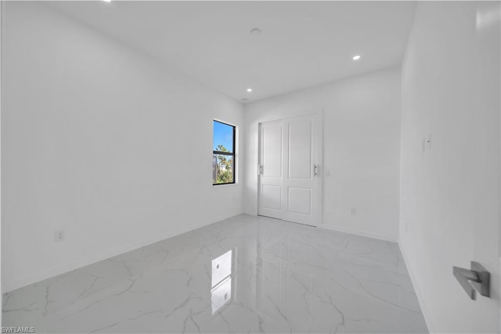 Unfurnished bedroom with recessed lighting and light marble finish floors