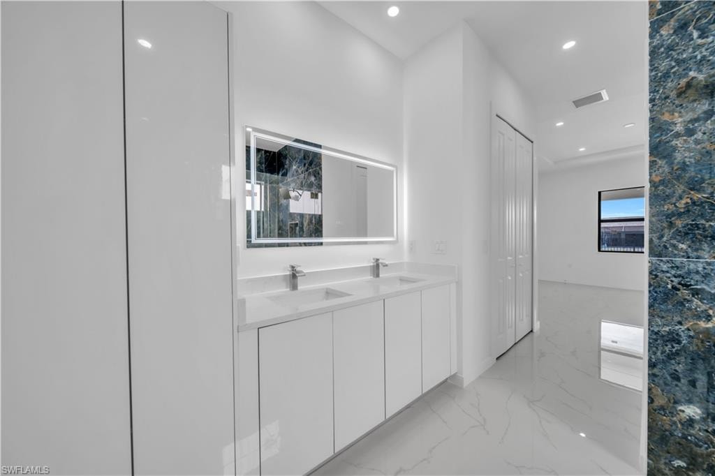 Hall featuring recessed lighting and light marble finish flooring