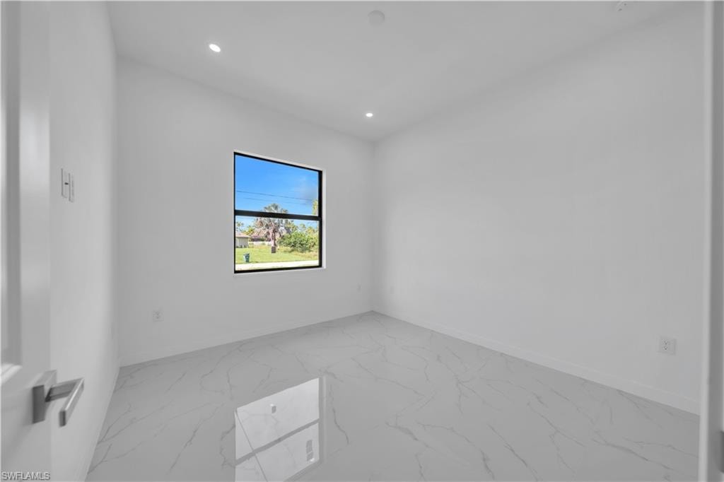 Unfurnished room featuring light marble finish floors and recessed lighting