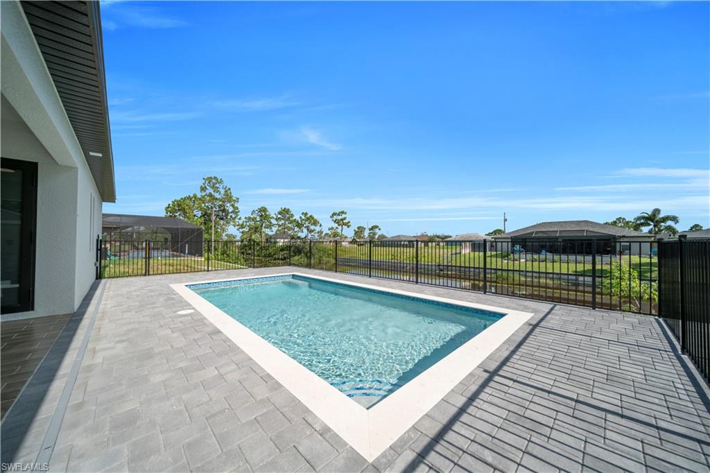 View of swimming pool featuring patio surround, a fenced backyard, and a residential view