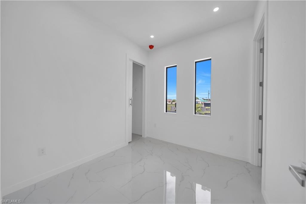 Unfurnished room featuring recessed lighting and light marble finish flooring