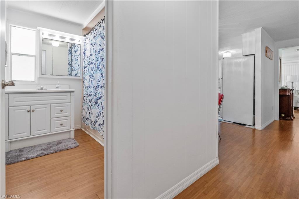 Bathroom with light wood-style floors, vanity, and curtained shower