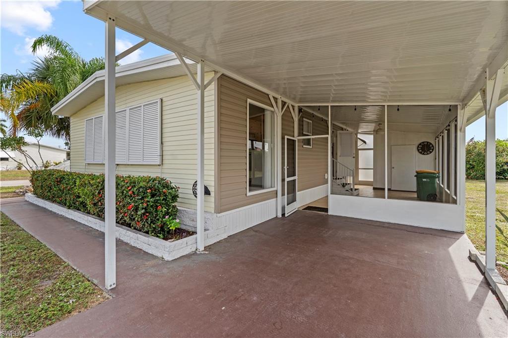 View of patio with a carport and a sunroom