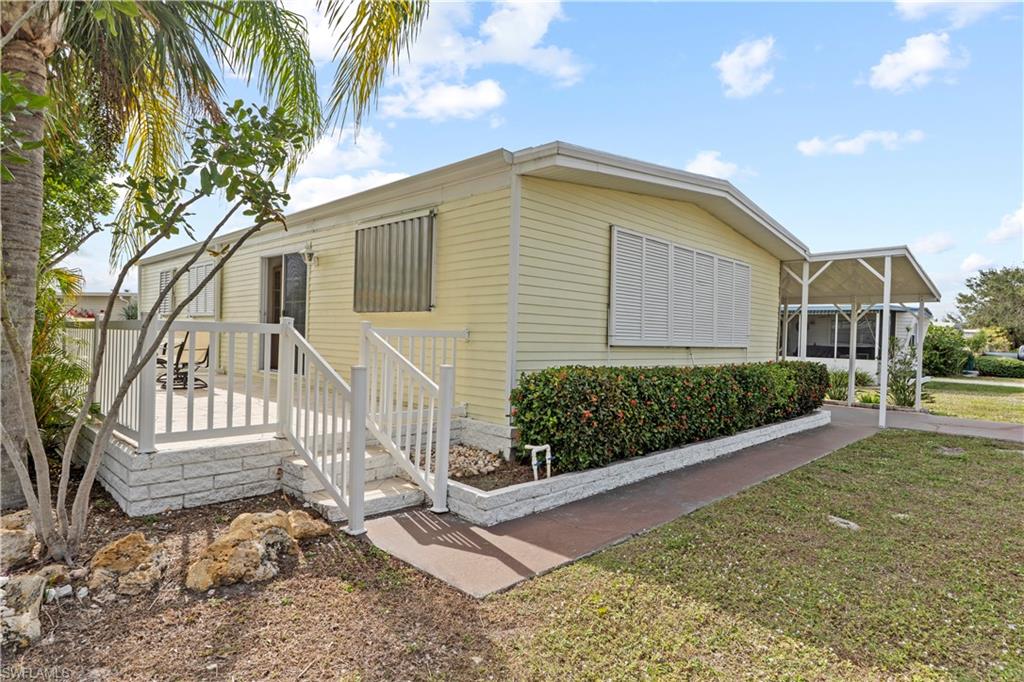 View of side of home with a lawn and a deck