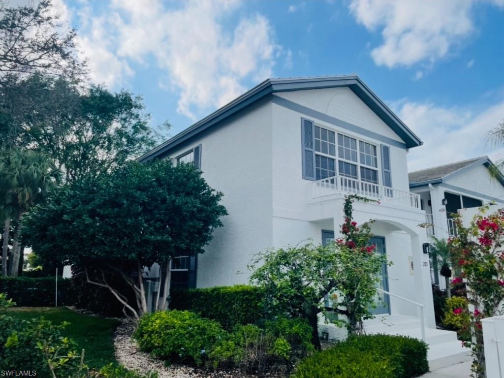 View of front of home featuring a balcony and stucco siding