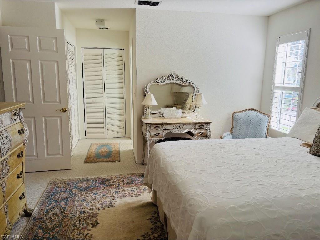 Bedroom featuring light carpet and a closet