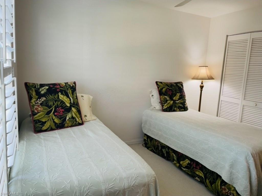 Bedroom with light carpet, a ceiling fan, and a closet
